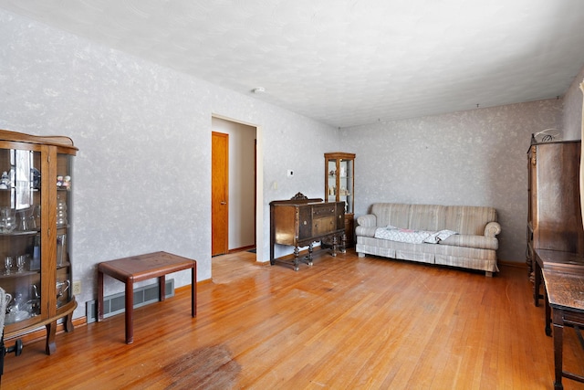 living area with visible vents and wood finished floors