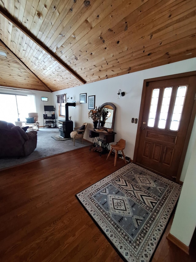 entryway featuring lofted ceiling, a wood stove, wood ceiling, and wood finished floors