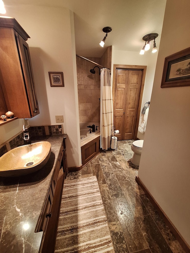 full bathroom with toilet, shower / tub combo, baseboards, and vanity