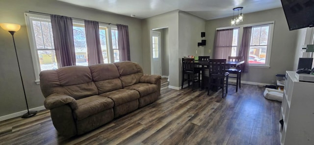 living room with dark hardwood / wood-style flooring and a healthy amount of sunlight