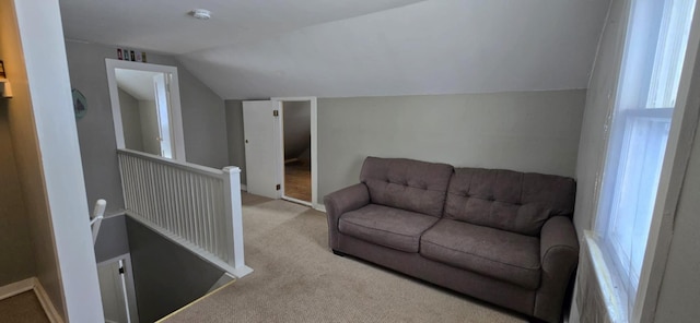 carpeted living room with a healthy amount of sunlight and vaulted ceiling