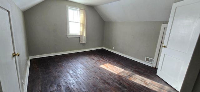 additional living space featuring vaulted ceiling and dark wood-type flooring