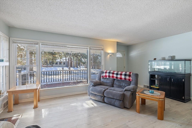 living room featuring a textured ceiling and light hardwood / wood-style floors