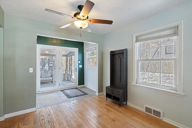 entrance foyer featuring plenty of natural light, light hardwood / wood-style flooring, and a textured ceiling