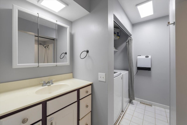 bathroom featuring tile patterned flooring, vanity, and washing machine and clothes dryer