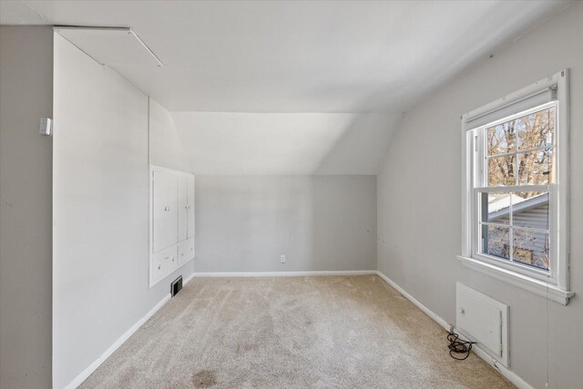 bonus room featuring lofted ceiling and light carpet