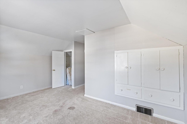 spare room with vaulted ceiling and light carpet