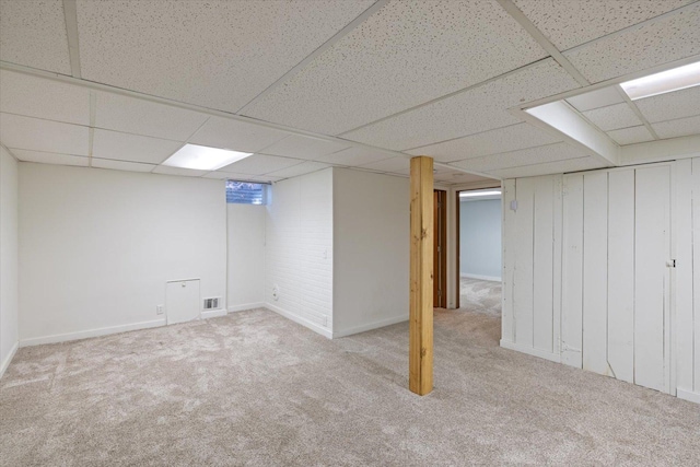 basement with light carpet and a drop ceiling