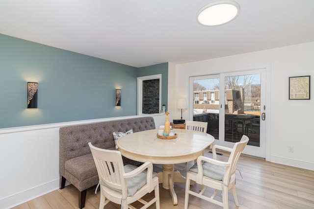 dining space featuring light wood-type flooring and baseboards