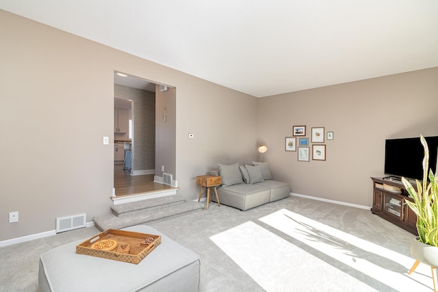 carpeted living room with baseboards and visible vents