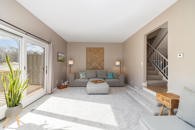 living room with carpet floors, baseboards, stairs, and visible vents