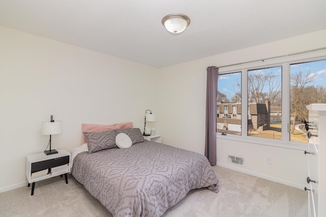 bedroom with light carpet, visible vents, and baseboards