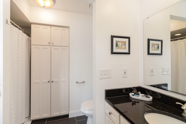 bathroom featuring toilet, vanity, and baseboards