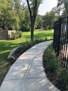 surrounding community with fence and a yard