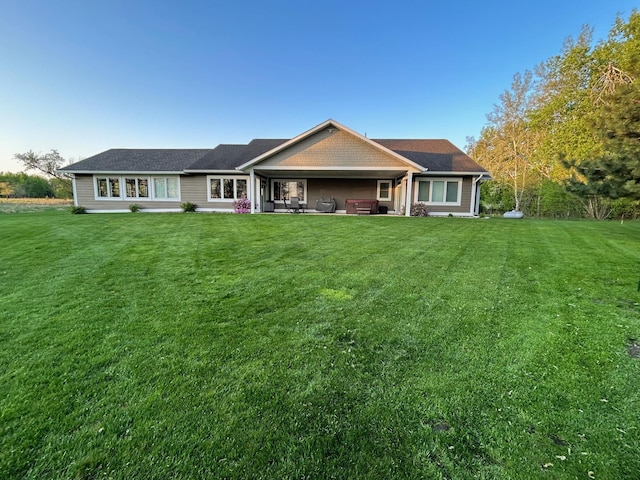 view of front of house with a front yard and a patio area