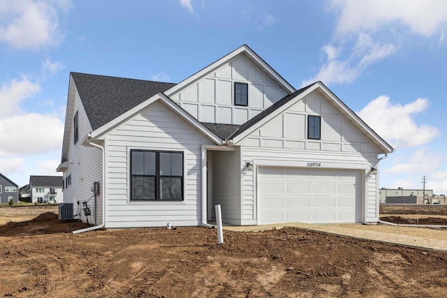 10974 37th St N, Lake Elmo, MN 55042 - view of front facade with a garage, central AC unit, a shingled roof, board and batten siding, and driveway