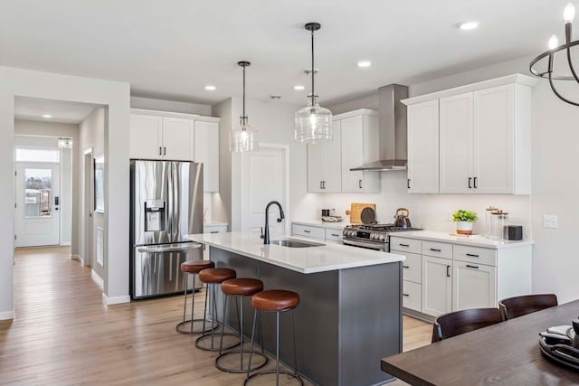 10974 37th St N, Lake Elmo, MN 55042 - kitchen featuring a sink, light wood-style floors, wall chimney exhaust hood, stainless steel appliances, and a kitchen bar