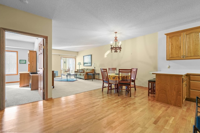 11030 Mississippi Blvd NW Unit 221, Coon Rapids, MN 55433 - dining area with light wood finished floors, a chandelier, a textured ceiling, and baseboards