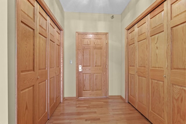 11030 Mississippi Blvd NW Unit 221, Coon Rapids, MN 55433 - doorway featuring light wood-style floors, a textured ceiling, and baseboards