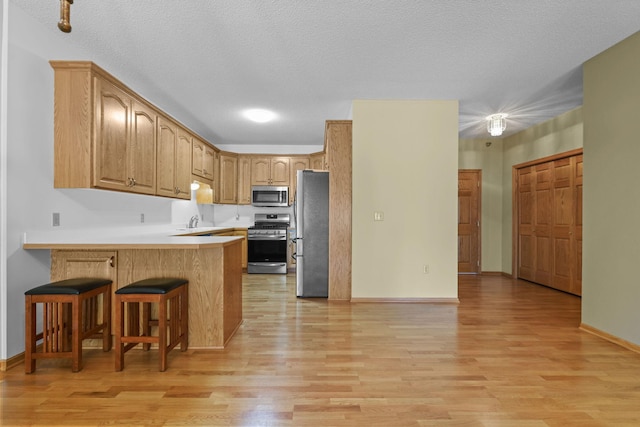 11030 Mississippi Blvd NW Unit 221, Coon Rapids, MN 55433 - kitchen with appliances with stainless steel finishes, a peninsula, and light wood-style flooring