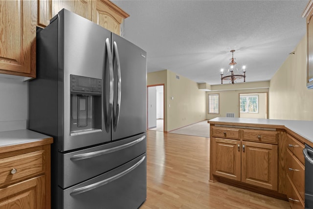 11030 Mississippi Blvd NW Unit 221, Coon Rapids, MN 55433 - kitchen featuring stainless steel refrigerator with ice dispenser, a chandelier, light wood-style flooring, open floor plan, and a peninsula