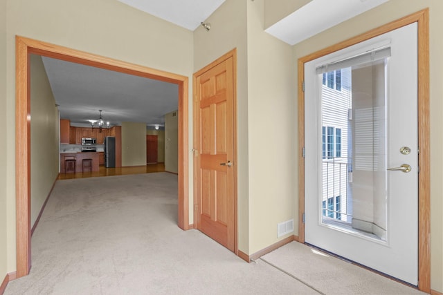 11030 Mississippi Blvd NW Unit 221, Coon Rapids, MN 55433 - corridor featuring a chandelier, light carpet, and baseboards