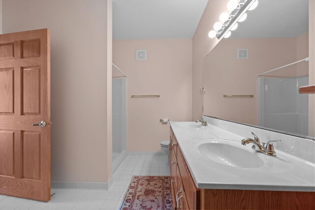 11030 Mississippi Blvd NW Unit 221, Coon Rapids, MN 55433 - bathroom featuring a stall shower, baseboards, double vanity, tile patterned floors, and toilet