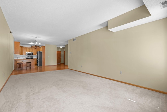 11030 Mississippi Blvd NW Unit 221, Coon Rapids, MN 55433 - unfurnished living room featuring a chandelier, light colored carpet, and baseboards