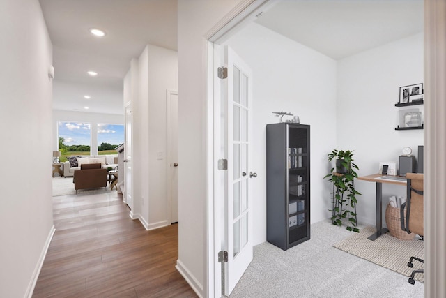 hallway with hardwood / wood-style floors and french doors