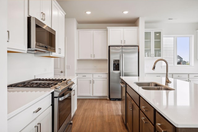 kitchen with appliances with stainless steel finishes, sink, and white cabinets