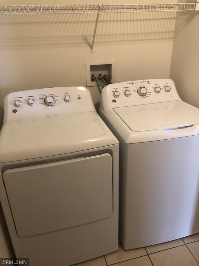 washroom featuring light tile patterned flooring, laundry area, and washer and dryer