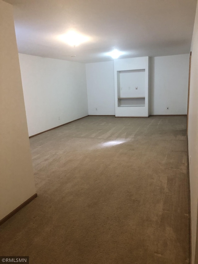 carpeted spare room featuring baseboards