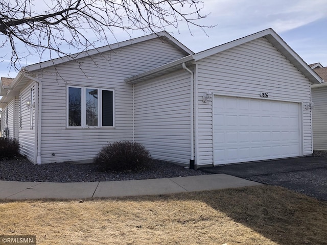 view of property exterior with aphalt driveway and an attached garage