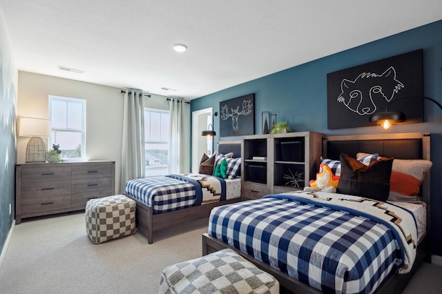 bedroom featuring light carpet and a textured ceiling