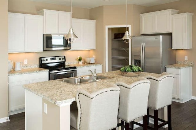 kitchen featuring white cabinetry, hanging light fixtures, sink, and appliances with stainless steel finishes