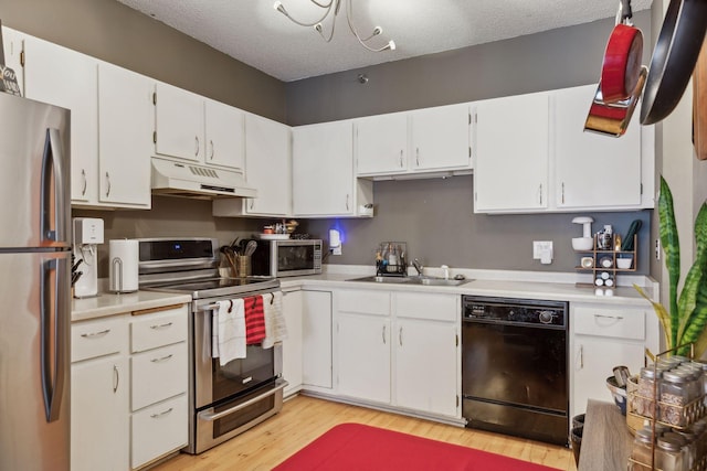 kitchen with sink, a textured ceiling, light hardwood / wood-style flooring, appliances with stainless steel finishes, and white cabinets