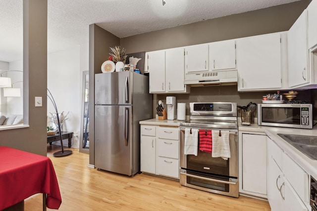 kitchen with white cabinetry, appliances with stainless steel finishes, a textured ceiling, and light hardwood / wood-style floors