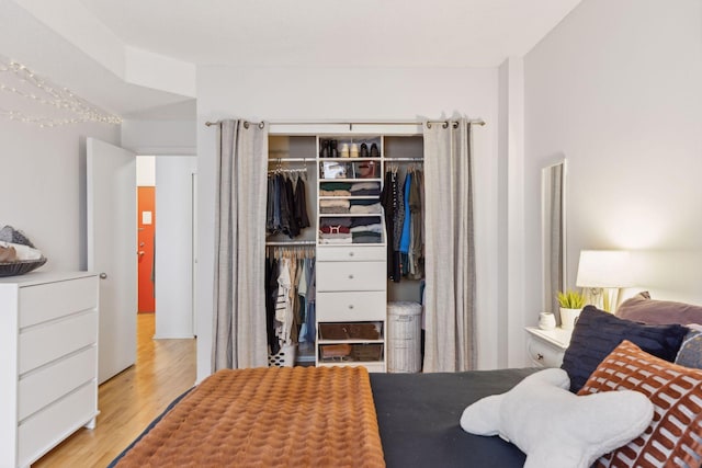 bedroom with light hardwood / wood-style flooring and a closet