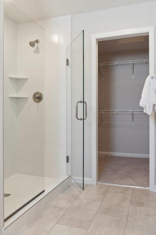 bathroom featuring an enclosed shower and tile patterned flooring