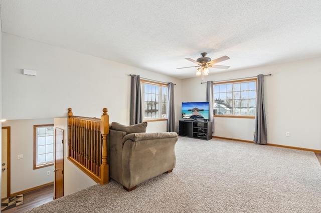 carpeted living room featuring ceiling fan, a wealth of natural light, and a textured ceiling