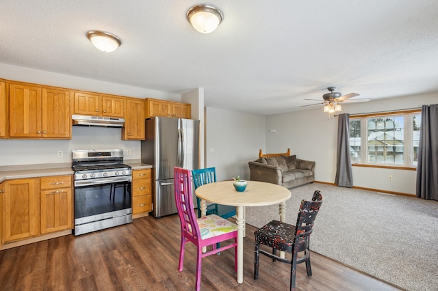 kitchen with stainless steel appliances, ceiling fan, a textured ceiling, and dark hardwood / wood-style flooring