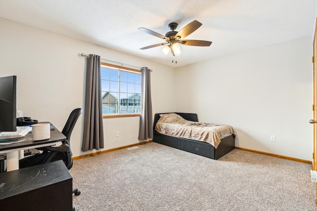 bedroom featuring ceiling fan, light colored carpet, and a textured ceiling