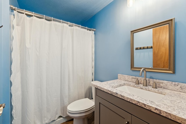 bathroom with vanity, toilet, and a textured ceiling