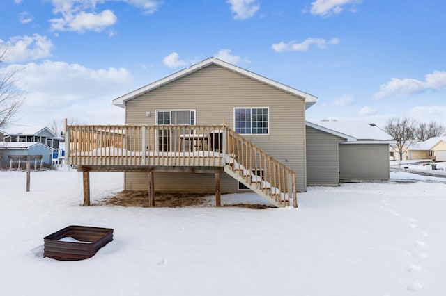 snow covered rear of property featuring a wooden deck