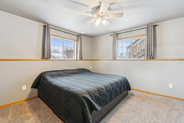 carpeted bedroom with ceiling fan and a textured ceiling