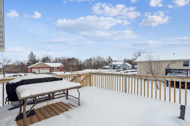 snow covered deck featuring a garage