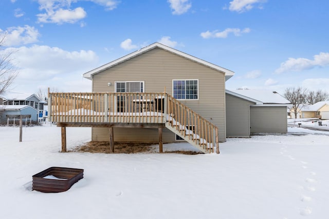 snow covered rear of property featuring a deck