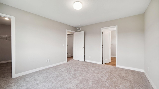 7472 170th Ave NW, Ramsey, MN 55303 - unfurnished bedroom with baseboards, visible vents, carpet, and a walk in closet