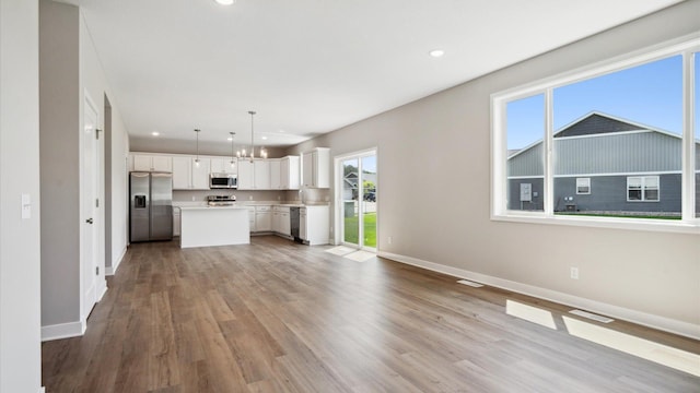 7472 170th Ave NW, Ramsey, MN 55303 - kitchen with baseboards, open floor plan, white cabinets, and appliances with stainless steel finishes