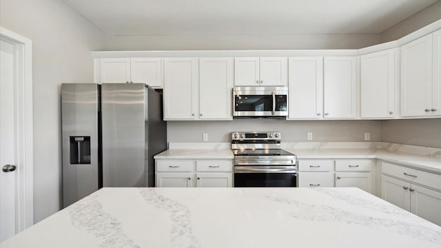 7472 170th Ave NW, Ramsey, MN 55303 - kitchen featuring white cabinetry, light stone counters, and appliances with stainless steel finishes
